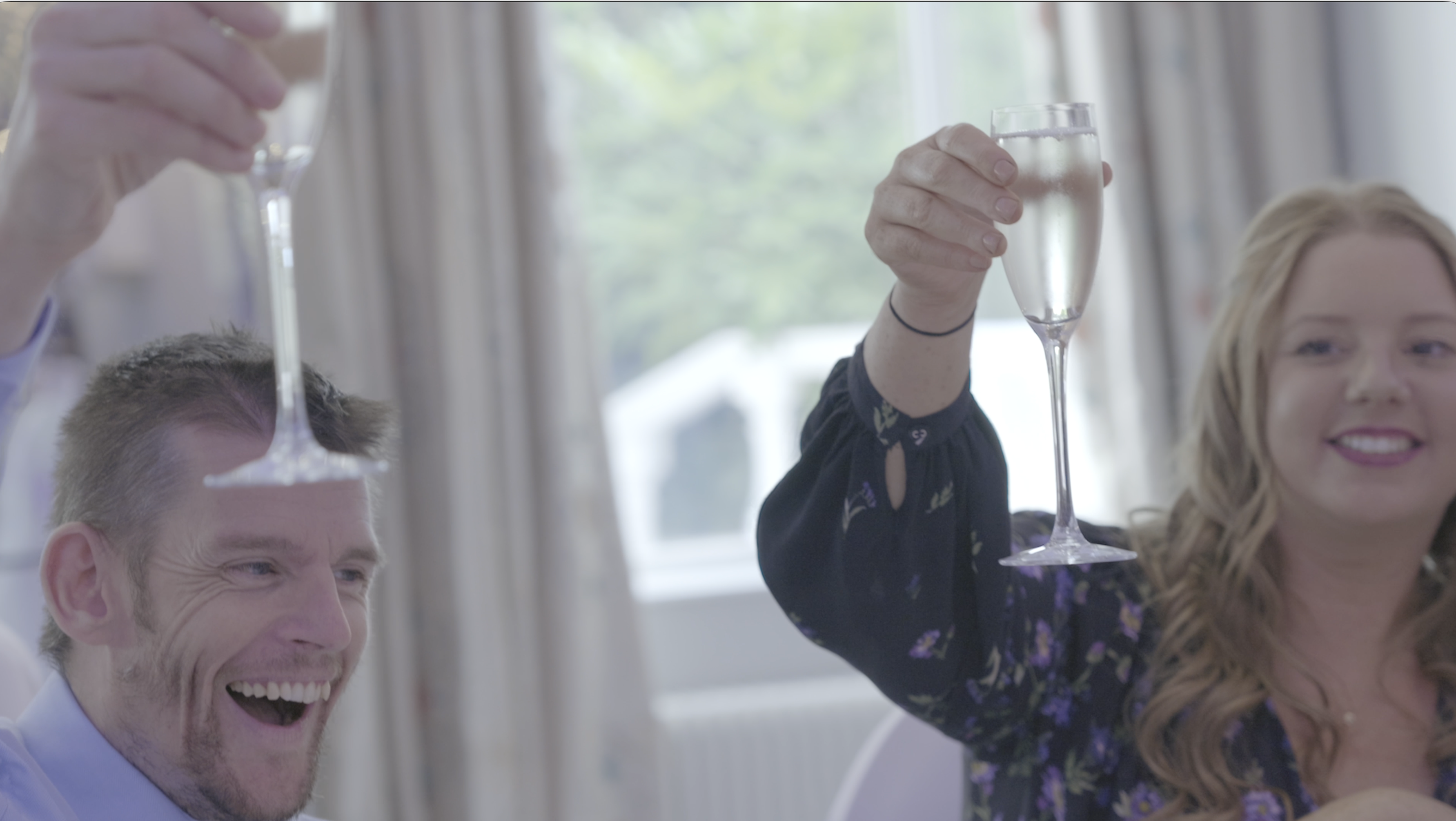 Wedding guests raising a glass during speeches at Thornton Hall on the Wirral