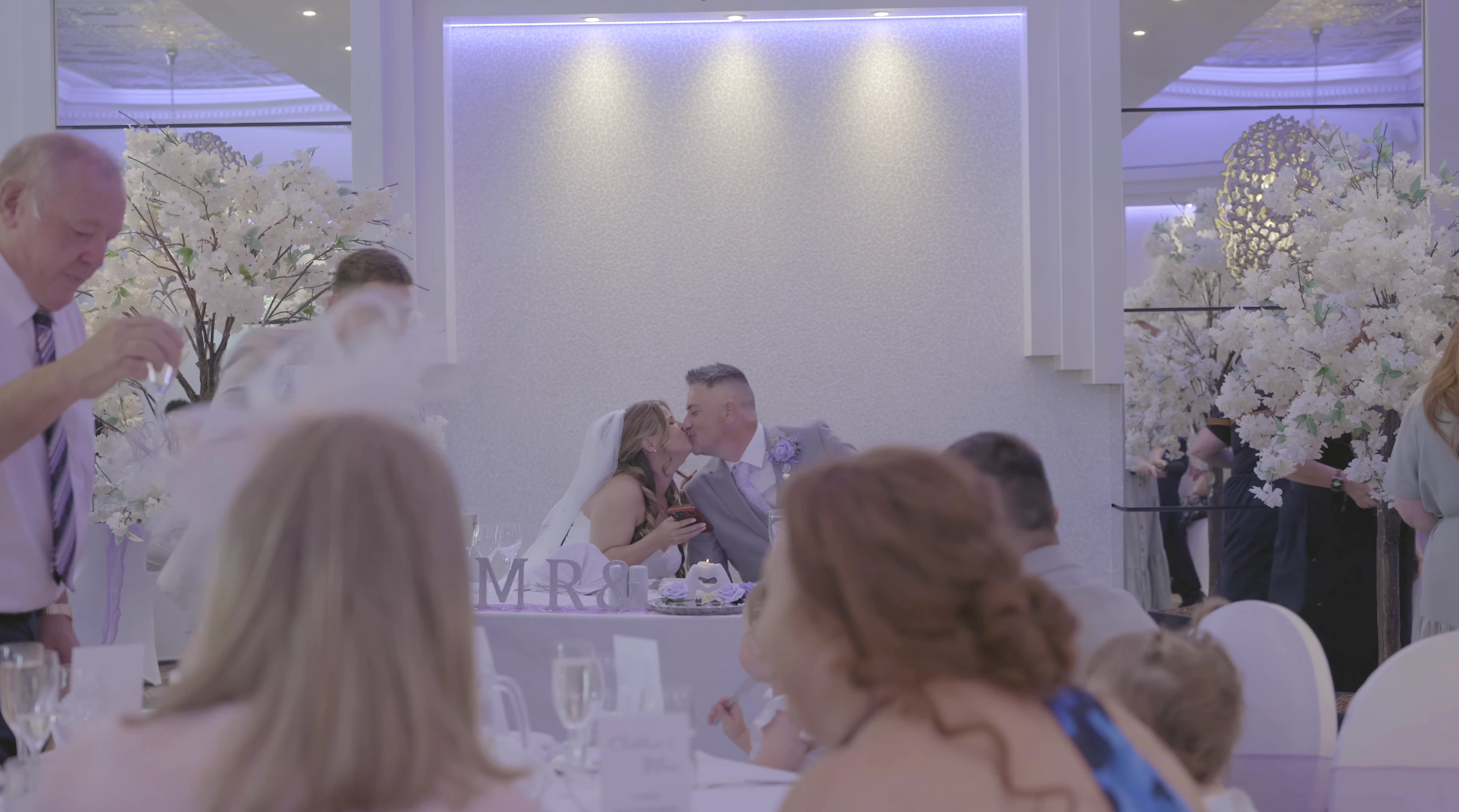 Bride and groom sharing a kiss during their wedding reception at Thornton Hall on the Wirral